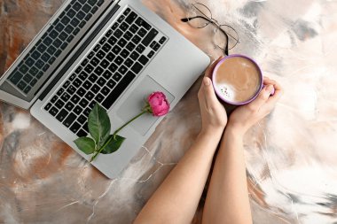 Fincan kahve ve renk arka plan üstünde laptop ile eller