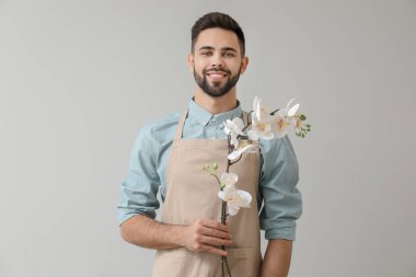 Işık arka plan üzerinde yakışıklı erkek çiçekçi