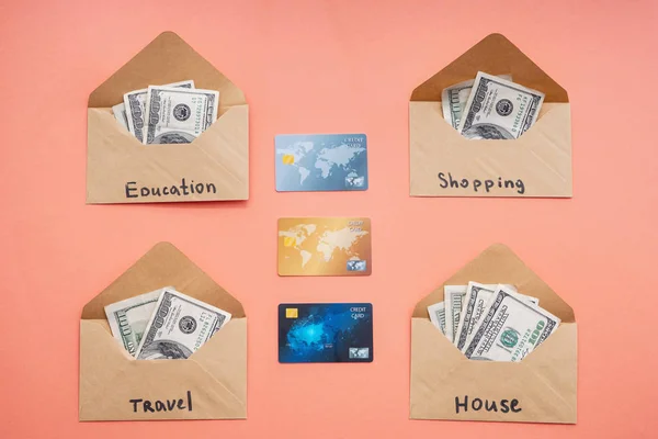 Zarflar farklı ihtiyaçları ve renk arka plan üzerinde kredi kartları için para ile. Tasarruf kavramı — Stok fotoğraf