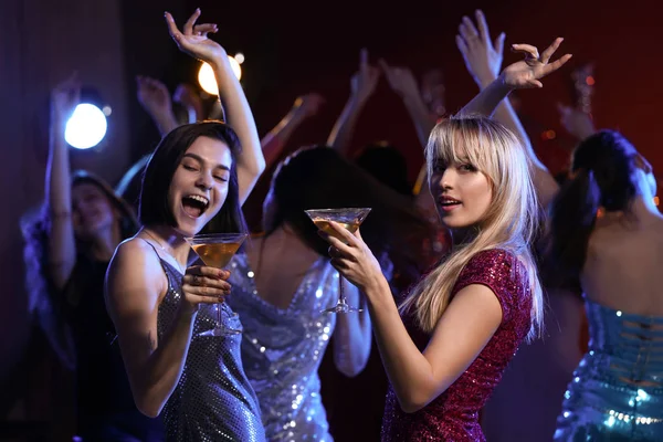 Beautiful young women with cocktails at party in night club — Stock Photo, Image