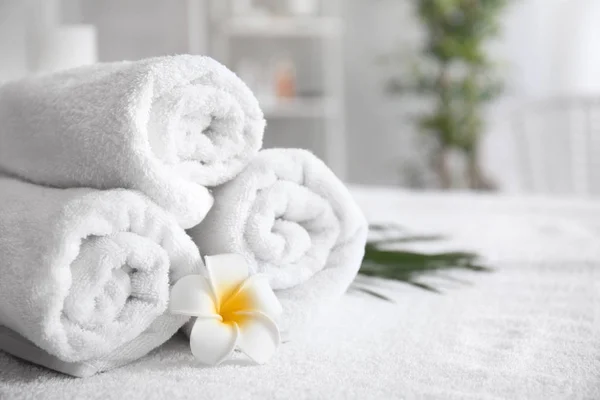 Rolled towels on table in spa salon — Stock Photo, Image