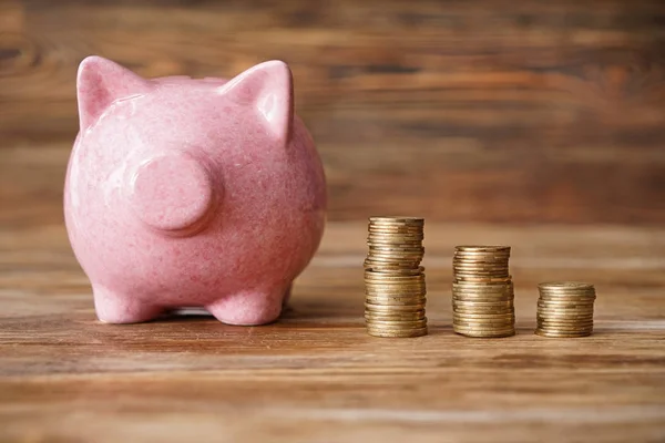 Hucha con dinero sobre fondo de madera — Foto de Stock