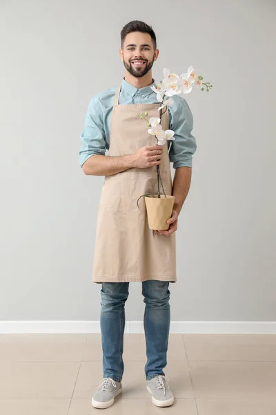 Handsome male florist near light wall — Stock Photo, Image