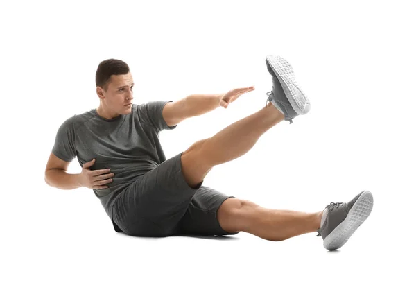 Sportlicher junger Mann beim Training vor weißem Hintergrund — Stockfoto