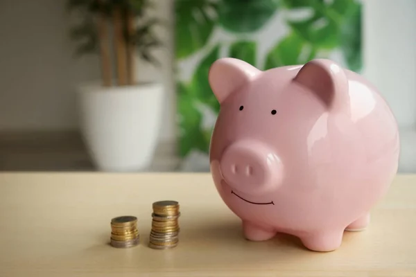 Банк свиней и монеты на столе — стоковое фото