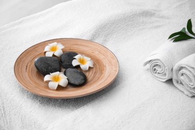 Plaka masaj taşlar ve spa salonda masaya çiçek