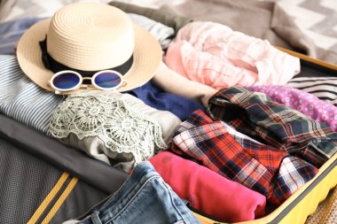 Yatakta elbise falan açık bavul. Seyahat kavramı