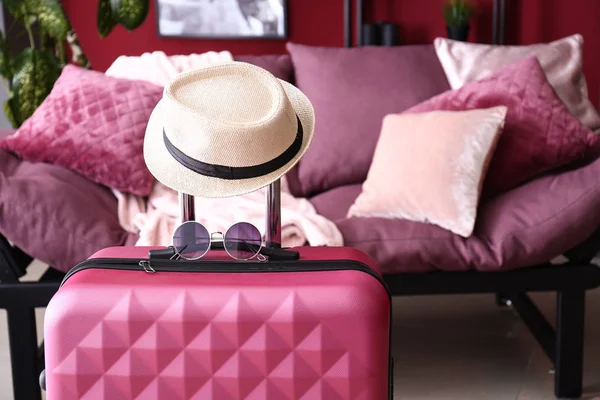 Packed suitcase and hat in room. Travel concept