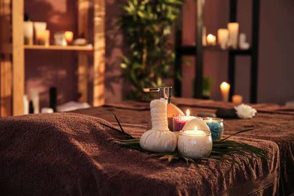 水疗沙龙桌子上的草药袋、化妆品和蜡烛 — 图库照片