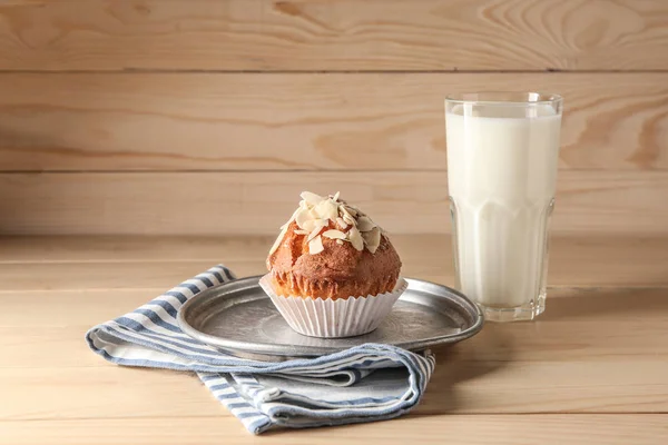Deska s chutné mandlové muffiny a mléka na dřevěný stůl — Stock fotografie