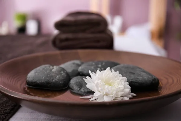 Spa stones and beautiful flower on plate — Stock Photo, Image