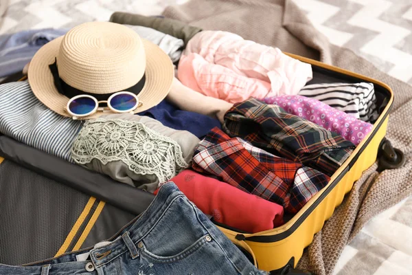 Ανοιχτό βαλίτσα με ρούχα και πράγματα στο κρεβάτι. Έννοια του ταξιδιού — Φωτογραφία Αρχείου