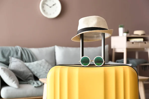 Packed suitcase, hat and sunglasses in room. Travel concept — Stock Photo, Image