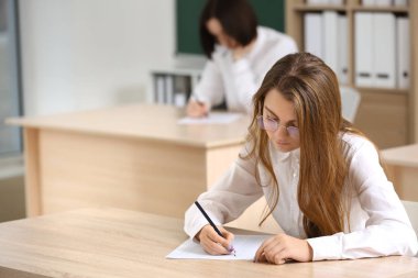 Girl passing school test in classroom clipart