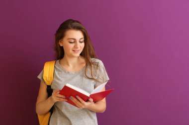 Renk arka plan üzerinde kitap ile kız öğrenci