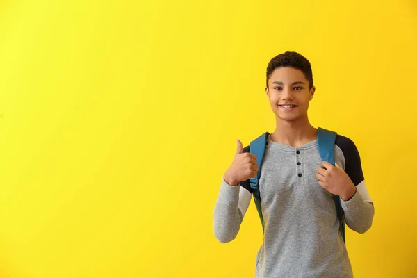 African-American schoolboy showing thumb-up on color background — Stock Photo, Image