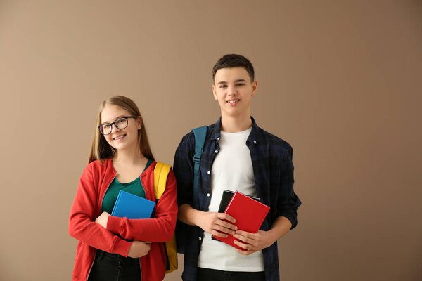 Ученики с книгами на цветном фоне
