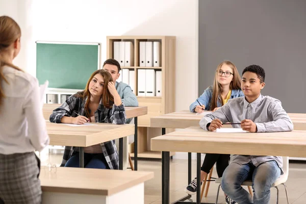 Alunos passando no teste escolar em sala de aula — Fotografia de Stock