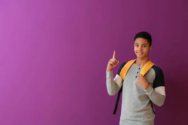 African-American schoolboy with raised index finger on color background — Stock Photo, Image