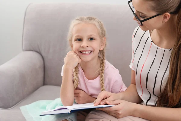 Klein meisje met Speech therapeut lezen boek in Office — Stockfoto