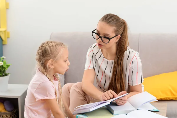 Little girl with speech therapist reading book in office — Stock Photo, Image