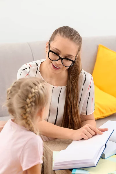 Mała dziewczynka z logopedy czytania książki w biurze — Zdjęcie stockowe