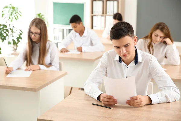 Alunos passando no teste escolar em sala de aula — Fotografia de Stock