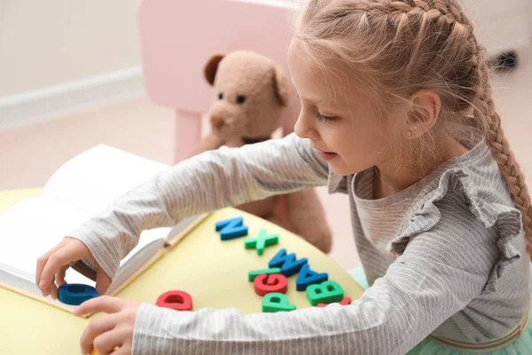 Little girl composing words of letters at speech therapist office — Stock Photo, Image