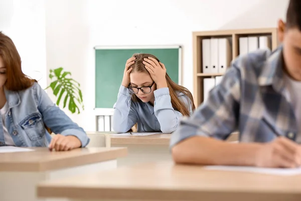 Stressed girl passing school test in classroom — Stock Photo, Image