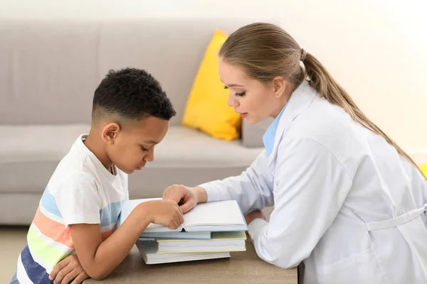 Niño pequeño con logopeda leyendo libro en la oficina — Foto de Stock