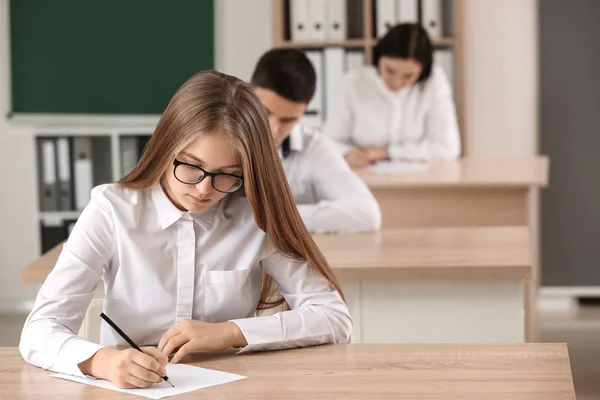 Alunos passando no teste escolar em sala de aula — Fotografia de Stock