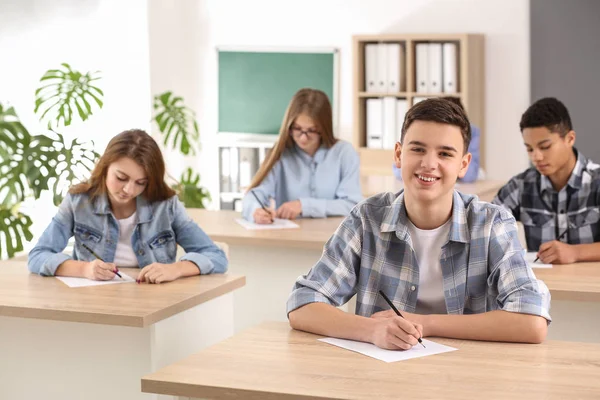 Alunos passando no teste escolar em sala de aula — Fotografia de Stock