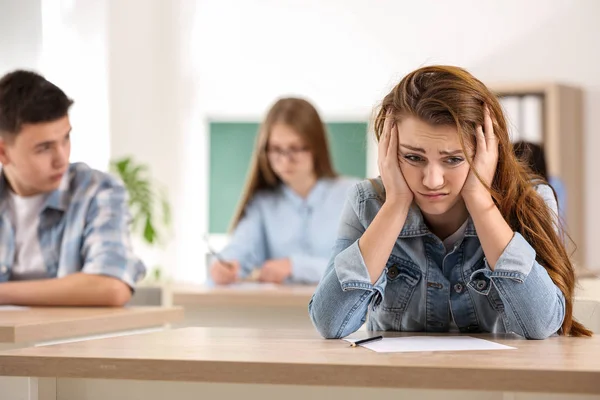 Chica estresada pasando la prueba de la escuela en clase — Foto de Stock