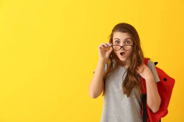 Geschokt school meisje op kleur achtergrond — Stockfoto