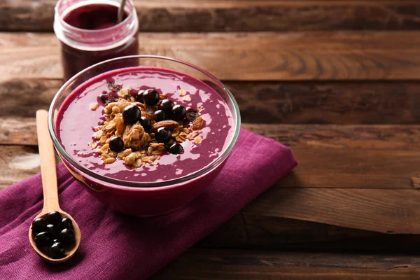 Bowl with tasty acai smoothie on wooden table — Stock Photo, Image