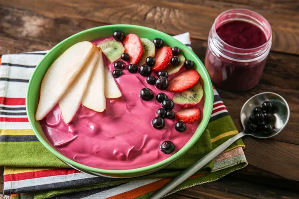 Bowl with tasty acai smoothie on wooden table — Stock Photo, Image