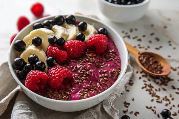 Bowl with tasty acai smoothie on light table — Stock Photo, Image