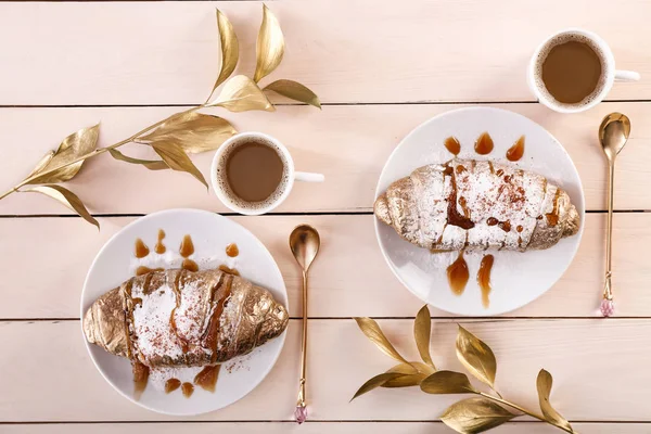 Composição com croissants dourados, decoração floral e xícaras de café na mesa de madeira — Fotografia de Stock