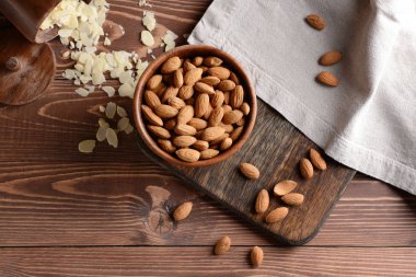 Bir kase lezzetli badem ve ahşap masa üzerinde pul