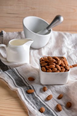 Lezzetli badem ve ahşap masa üzerinde süt ile kase