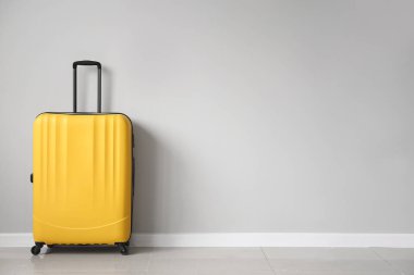 Işık duvarının yanında paketlenmiş bavul