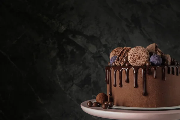 Stand com bolo de chocolate doce no fundo escuro — Fotografia de Stock