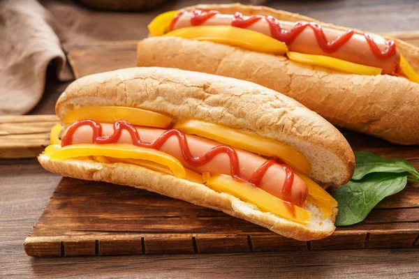 Tasty hot dogs on wooden board — Stock Photo, Image