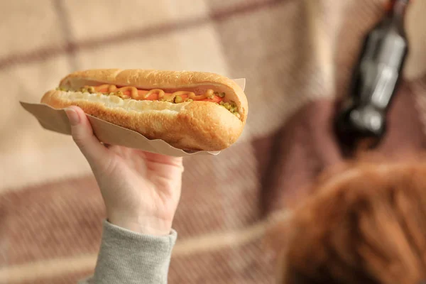 Mano femenina con sabroso perrito caliente, primer plano — Foto de Stock