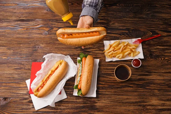 Kvinna klämma senap från flaska till välsmakande varmkorv — Stockfoto