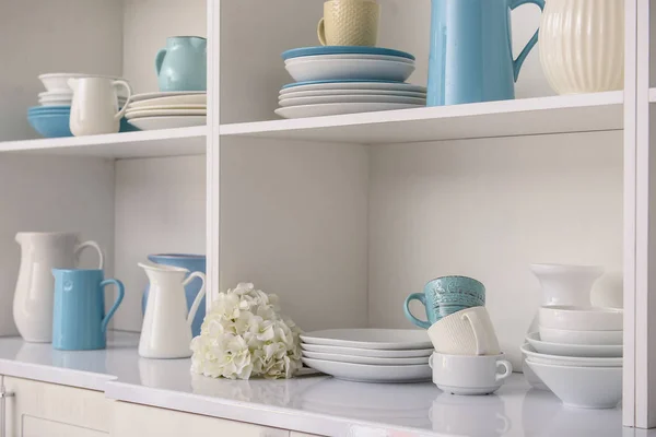 Set de platos limpios en estantes blancos en cocina — Foto de Stock