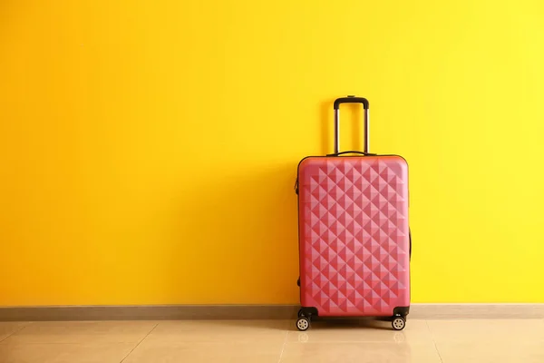 Συσκευασμένη βαλίτσα κοντά στον χρωματικό τοίχο — Φωτογραφία Αρχείου