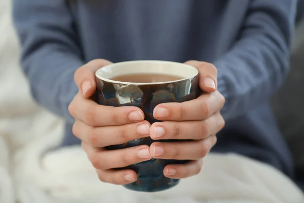 Jeune femme buvant du thé chaud à la maison, gros plan — Photo