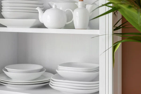 Set de platos limpios en estantes en cocina — Foto de Stock