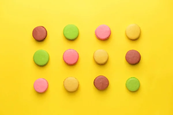 Tasty macarons on color background